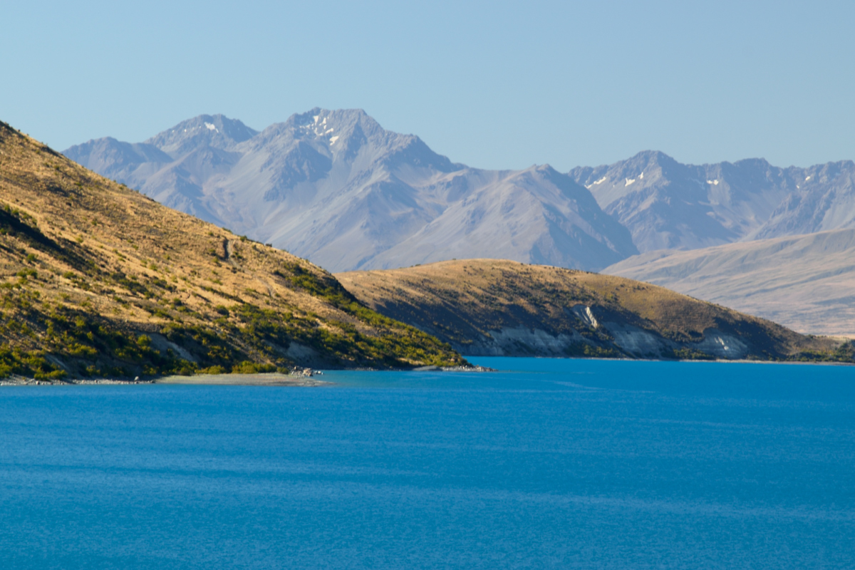 Lake Tekapo super blue water from glacier with Mackenzie base mountains in background